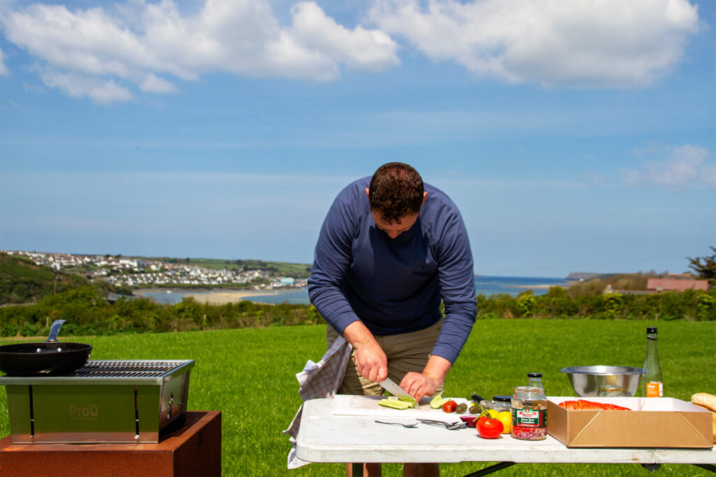 chef rupert copper of philleigh way cookery school making lobster rolls outside overlooking the sea at padstow