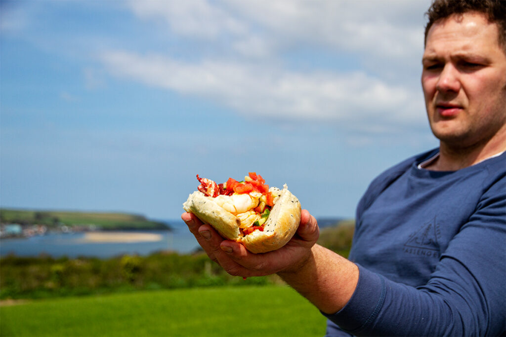 chef rupert cooper holding up a lobster roll