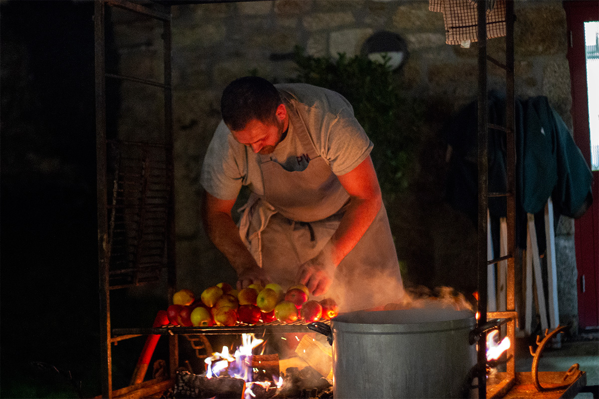 chef rupert cooper cooking apples over fire at a bonfire night feast at knightor winery
