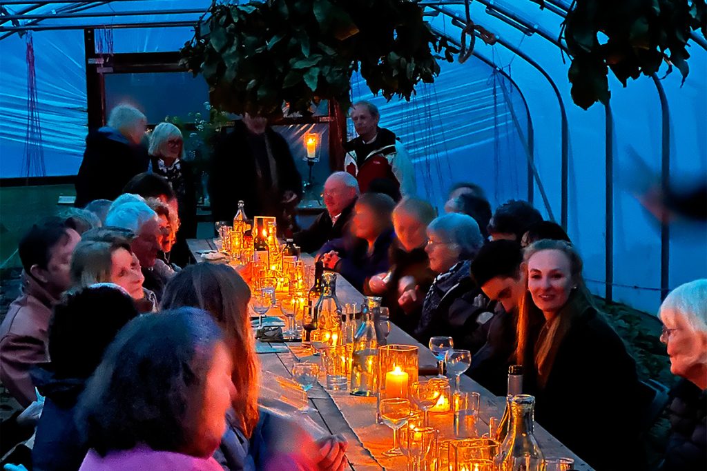 garden supper served on a long table laid in a polytunnel at roseland market garden for the roseland festival