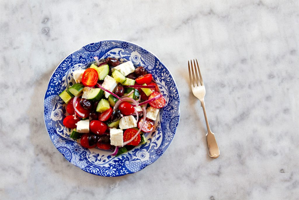 plate of horiatiki greek salad on a marble table