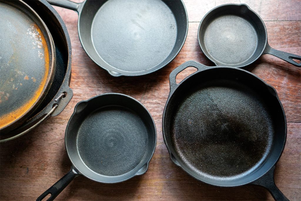 a collection of new and old cast iron cookware
