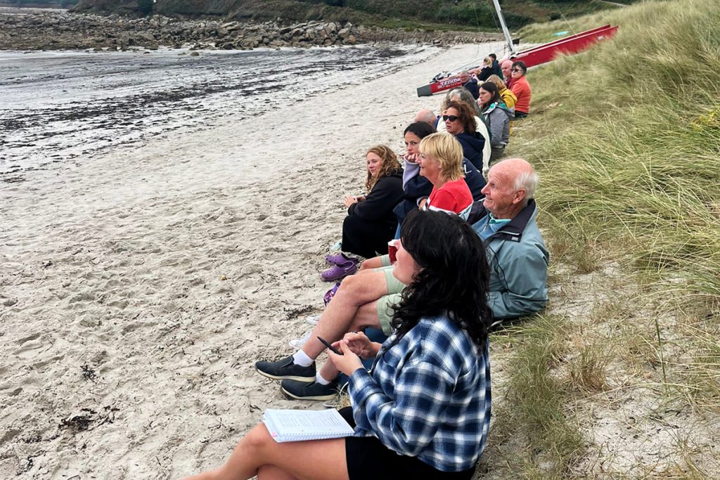 diners sitting on porthmellon beach ready for rupert cooper's woodifred feast at taste of scilly festival